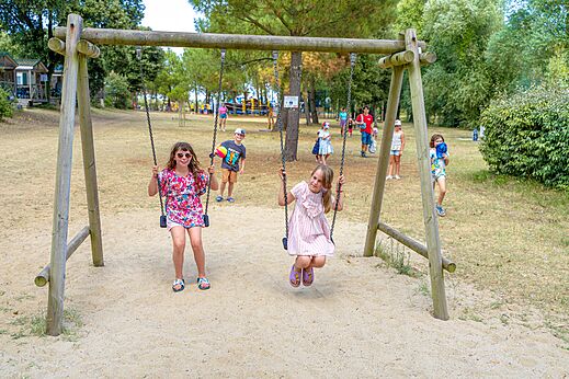 Holzschaukel mit spielenden Kindern auf dem Campingplatz CAPFUN Zagarella in LONGEVILLE SUR MER (85).