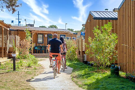 Paar fährt Fahrrad auf Weg zwischen Mobil-homes auf Camping CAPFUN Zagarella in LONGEVILLE SUR MER (85).