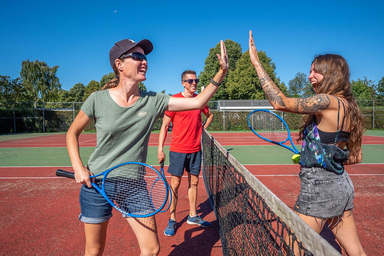 Lachende Tennisspieler auf dem Multisportplatz des Campingplatzes CAPFUN Zeumersehof in Voorthuizen.