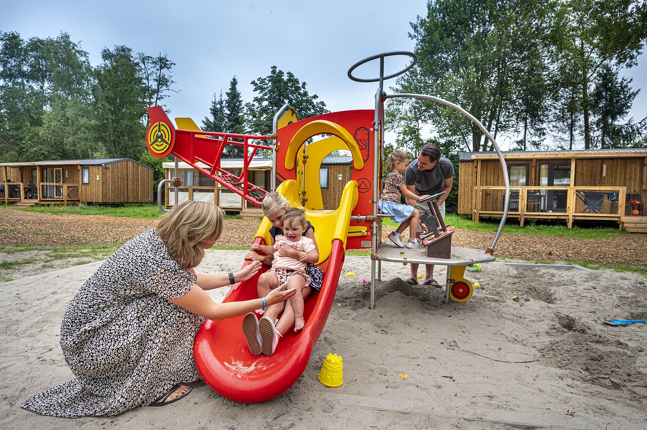 Rutsche, spielende Kinder, Mobilheime auf dem Campingplatz CAPFUN Zeumersehof in Voorthuizen.